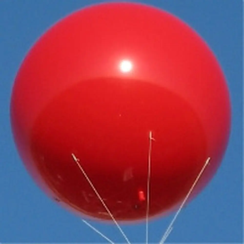 Red helium advertising sphere balloon against blue sky